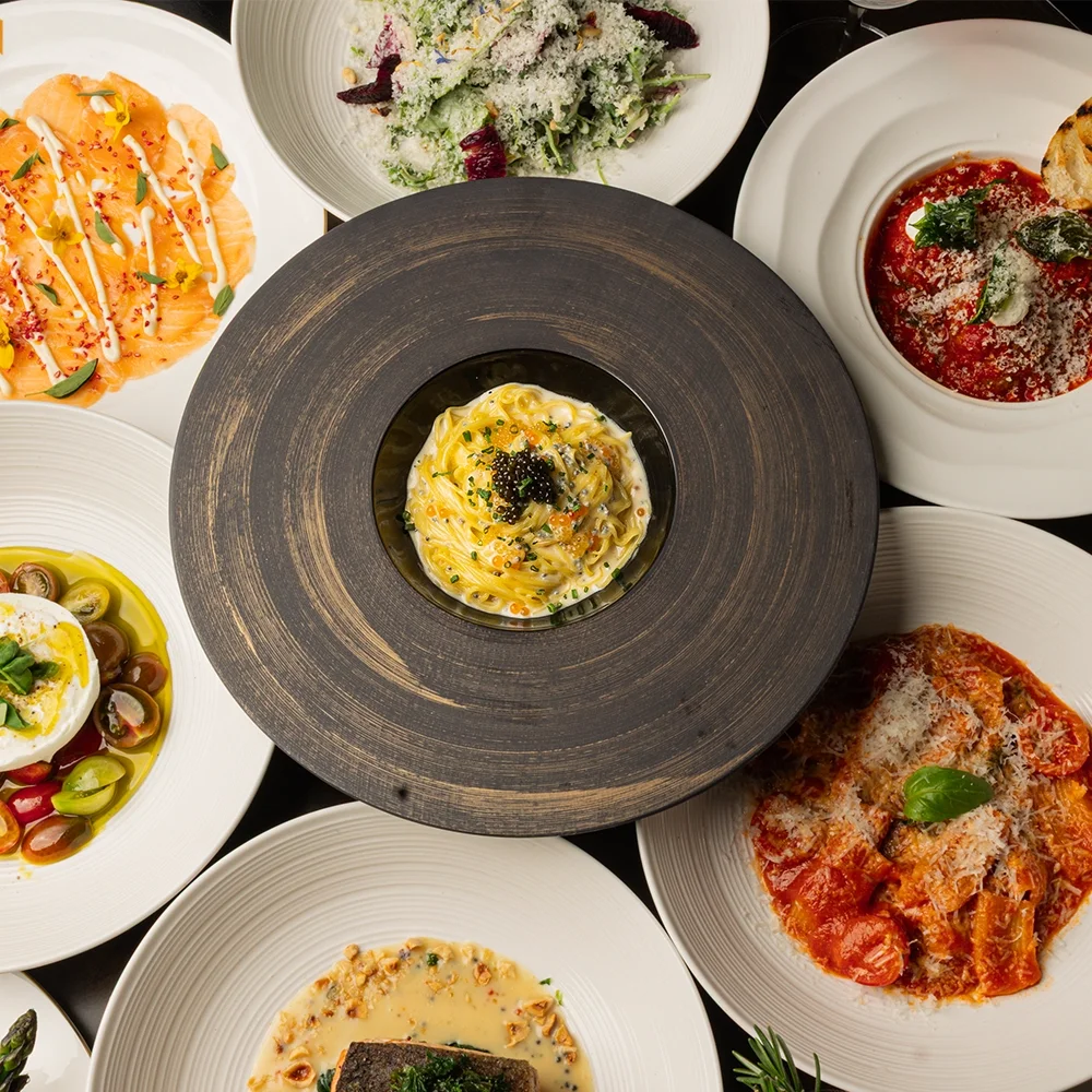 Overhead spread of Italian dishes including pasta, risotto and antipasti