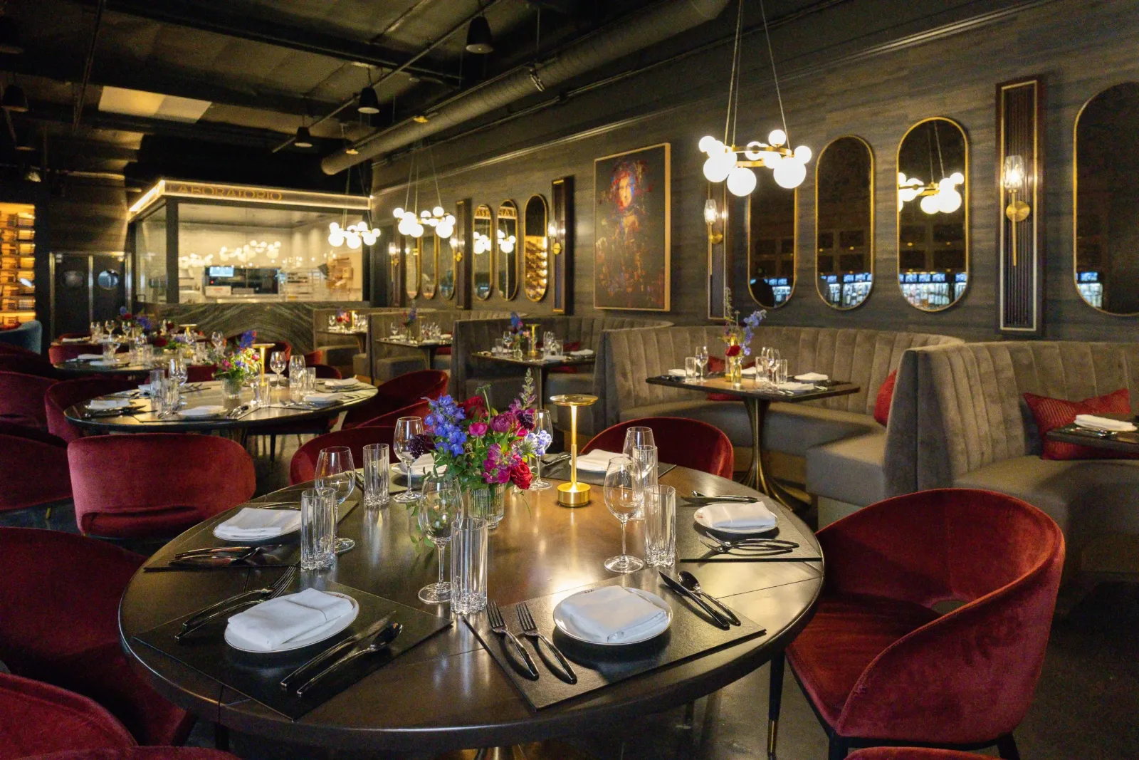 Round table set with fresh flowers, glassware and place settings at WeVINO
