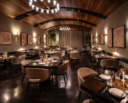 WeVINO dining room with chandeliers, tan chairs and a vaulted wood ceiling